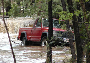 Photo of a truck being washed away on a flooded highway