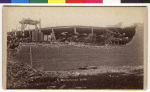 The T. P. Hall Buggy Works lost part of the roof and the side of the building in the tornado. Carriages and wagons are visible as well as the remains of an freight elevator structure. The business was located on the corner of College Street and Main Street.