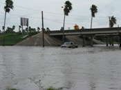 Truck navigating floodwaters below expressway (click to enlarge)