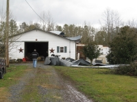 [ Two thirds of a tin roof was torn off a barn. ]