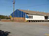 [ blue tarp and plywood repairs to one end of building ]