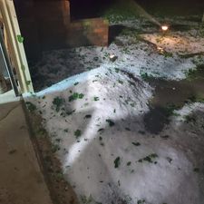 Piles of hail near a building.