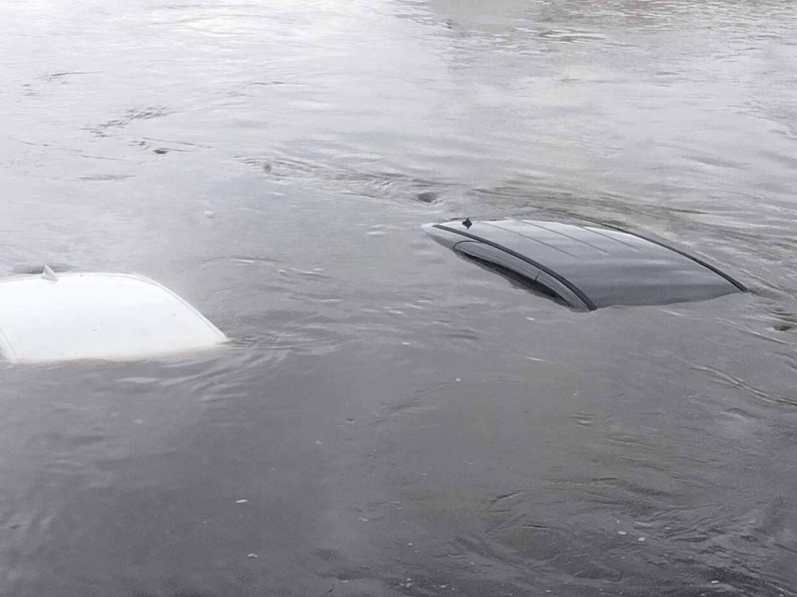 Cars submerged to the roof in flood waters in Spencer Iowa