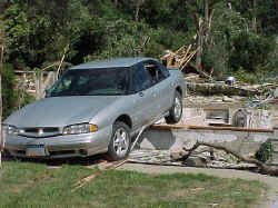 Car lifted onto house foundation.