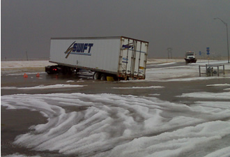 A tractor-trailer stuck in the flowing water and hail at a truck stop in Tulia