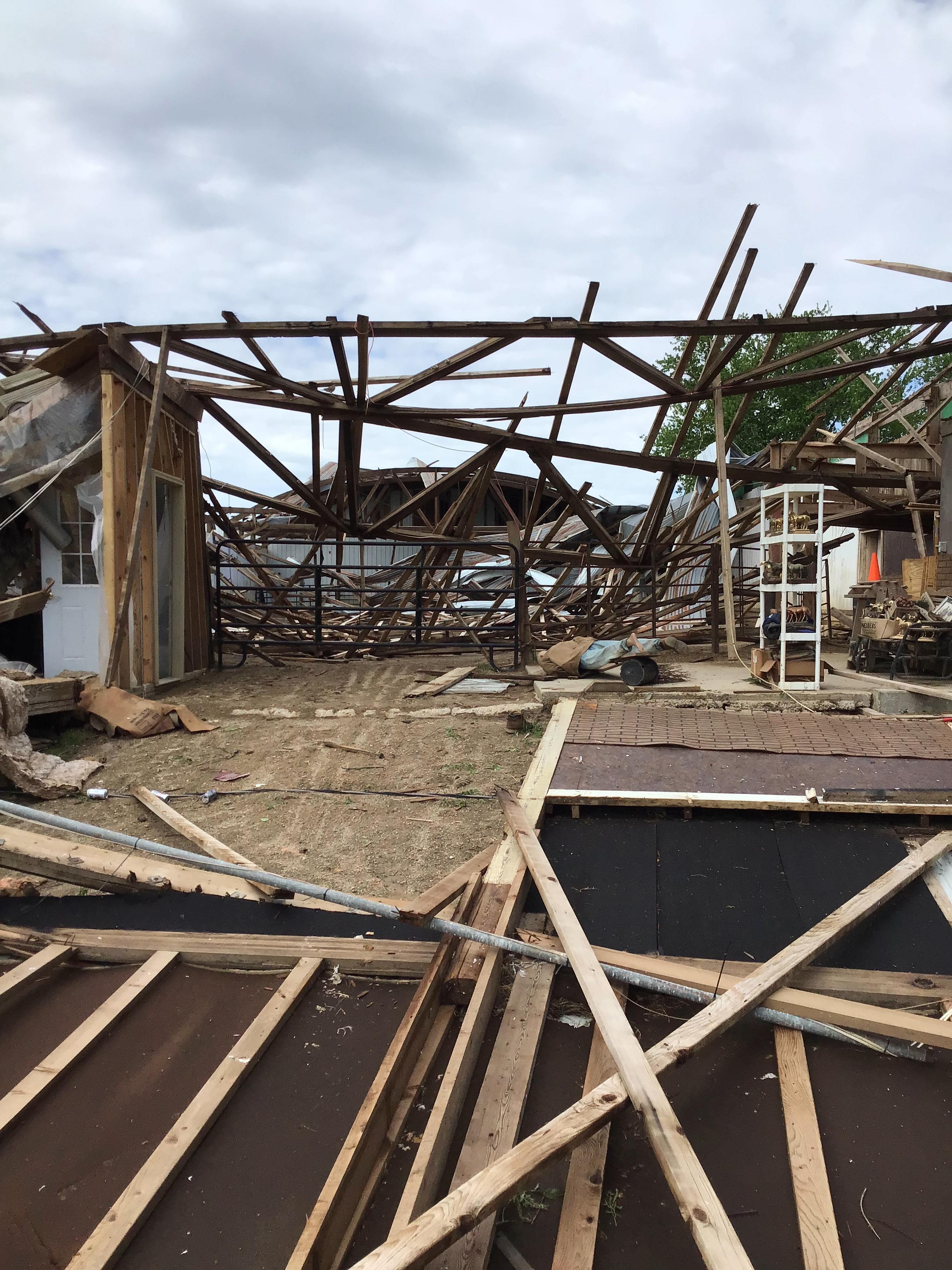 Photo of horse stable with the roof collapsed and walls blown in