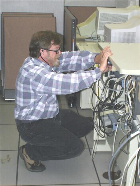 A picture of one of our HMTs connecting cables to one of our computers.