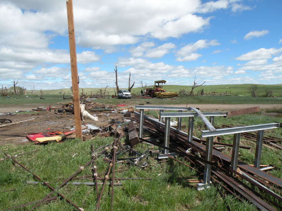 Destruction of pole barn (foreground), with van and hay swather thrown into trees