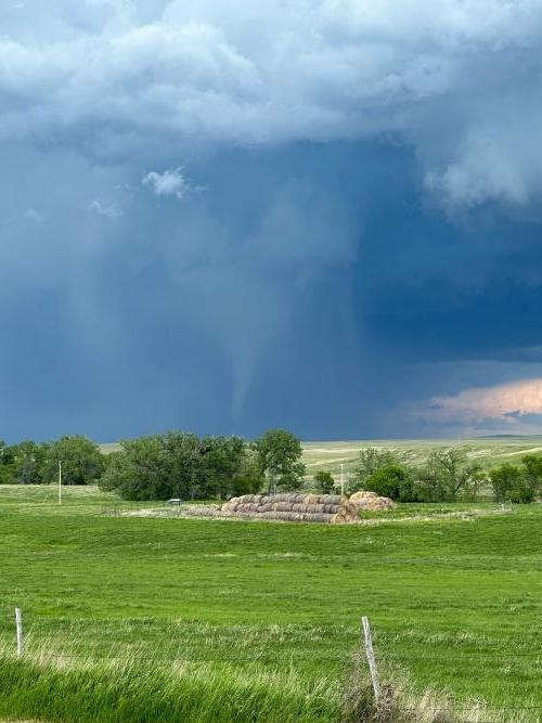 A tornado in an open field near Faith, South Dakota. Rain and hail have begun to obscure the funnel.