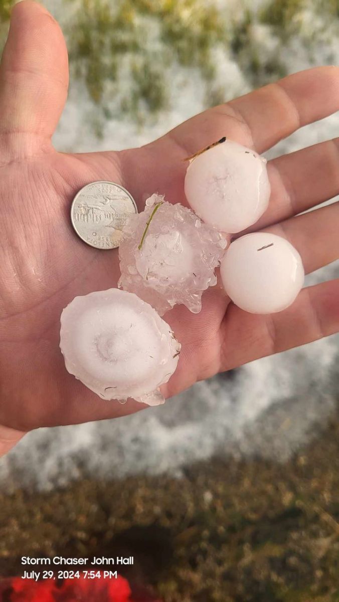 Hand holding large hailstones, some golf ball sized